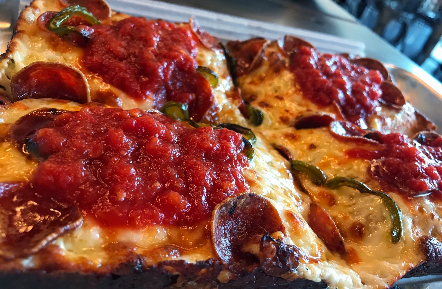 Michigan & Trumbull signature dishes Packard Pepperoni (with natural casing pepperoni that cups and crisps), Woodward White (white pizza), Custom Detroit-style pizzas with various toppings.