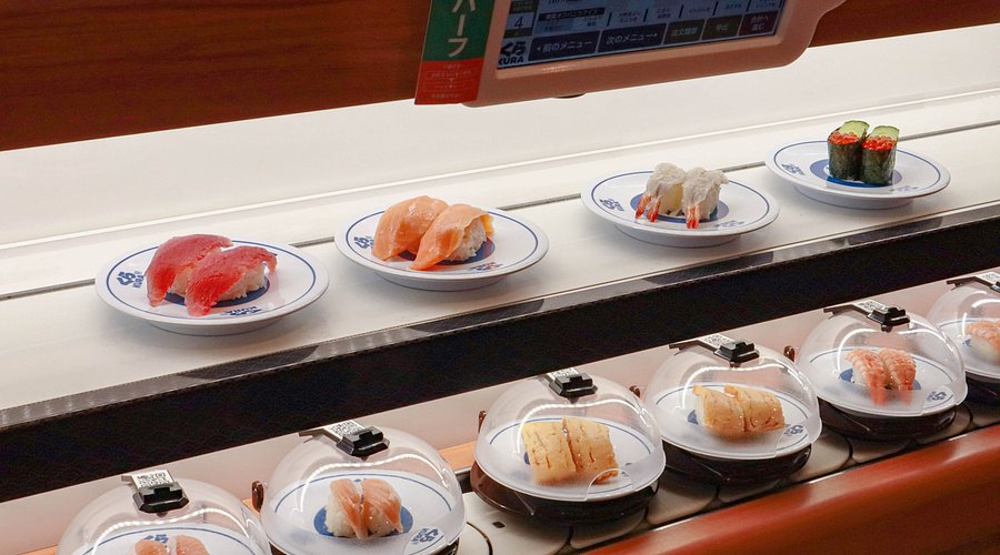 Kura Revolving Sushi Bar signature dishes The menu consists of small plates of nigiri, rolls, and other items. Popular choices include Tuna Nigiri, Seared Beef with Miso, and various specialty rolls.
