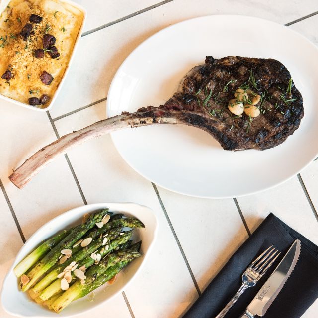 Cowford Chophouse signature dishes Cowford Cut (32 oz. Tomahawk Ribeye), Lobster Mac & Cheese, Seared Diver Scallops, Wagyu Beef Tartare